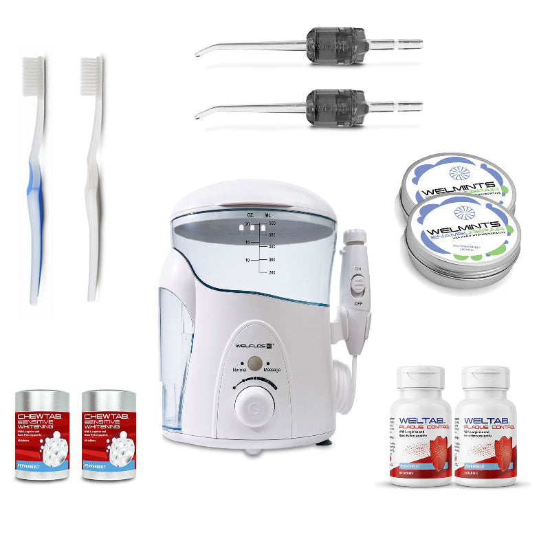 A white oral irrigator water flosser set with a clear water tank, handpiece, toothbrush, two black Weltips, a small red-and-white bottle,  an aluminum container with mints, and a white-and-red bottle on a plain white background.