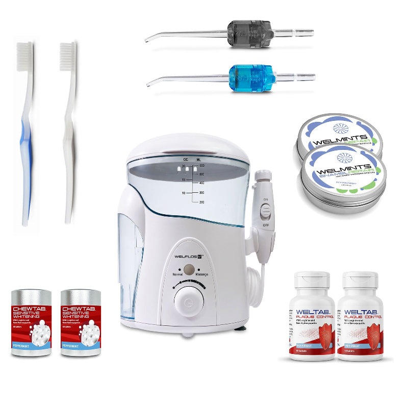 A white oral irrigator water flosser set with a clear water tank, handpiece, toothbrush,  black Weltip, blue Weltip, a small red-and-white bottle,  an aluminum container with mints, and a white-and-red bottle on a plain white background.