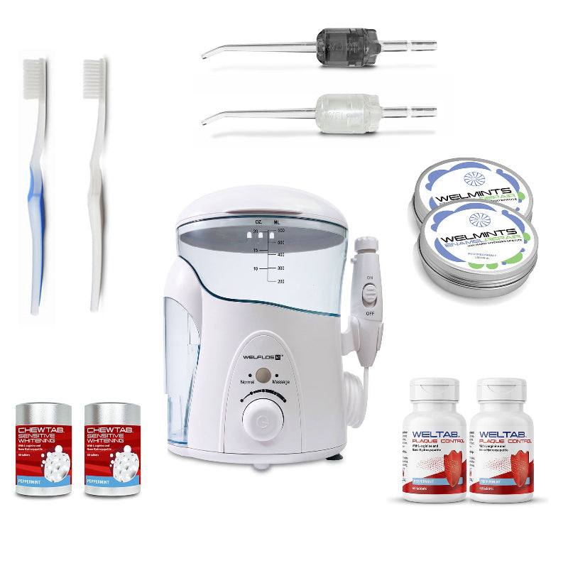 A white oral irrigator water flosser set with a clear water tank, handpiece, toothbrush,  black Weltip, clear Weltip, a small red-and-white bottle,  an aluminum container with mints, and a white-and-red bottle on a plain white background.