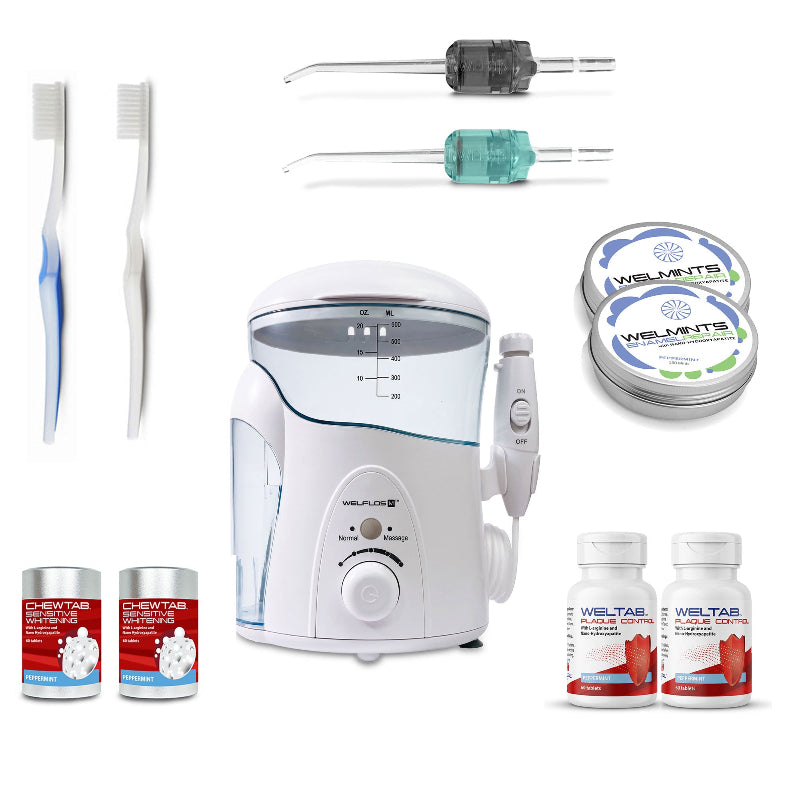 A white oral irrigator water flosser set with a clear water tank, handpiece, toothbrush,  black Weltip, seafoam Weltip, a small red-and-white bottle,  an aluminum container with mints, and a white-and-red bottle on a plain white background.