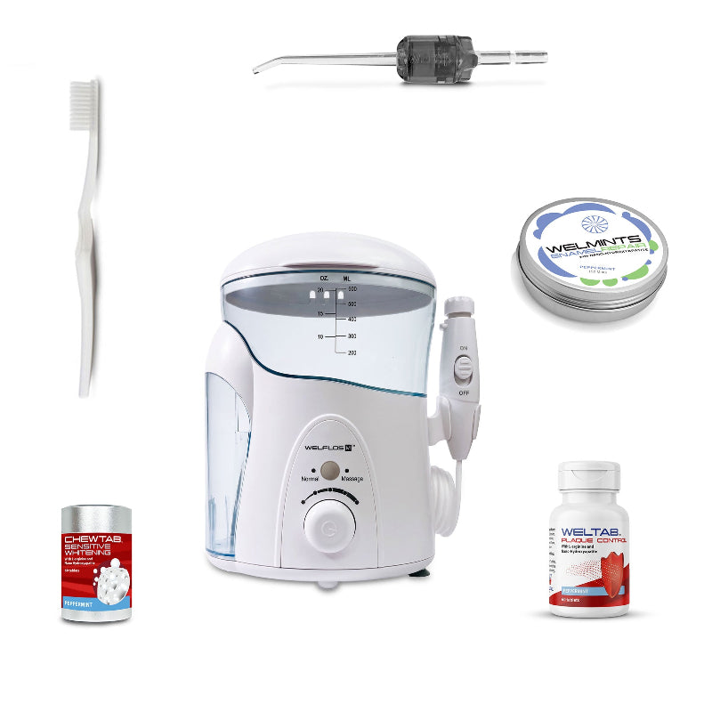 A white oral irrigator water flosser set with a clear water tank, handpiece, toothbrush, a black Weltip, a small red-and-white bottle,  an aluminum container with mints, and a white-and-red bottle on a plain white background.