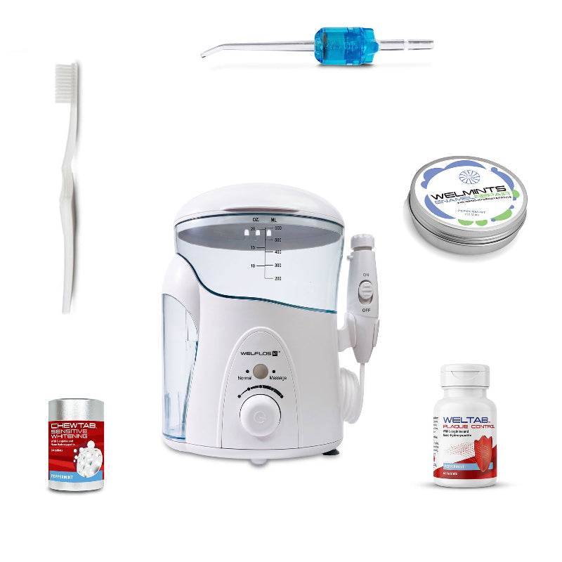 A white oral irrigator water flosser set with a clear water tank, handpiece, toothbrush, a blue Weltip, a small red-and-white bottle,  an aluminum container with mints, and a white-and-red bottle on a plain white background.