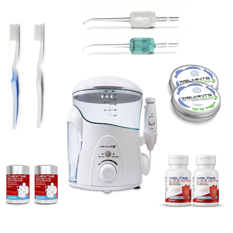 A white oral irrigator water flosser set with a clear water tank, handpiece, toothbrush,  seafoam Weltip, clear Weltip, a small red-and-white bottle,  an aluminum container with mints, and a white-and-red bottle on a plain white background.