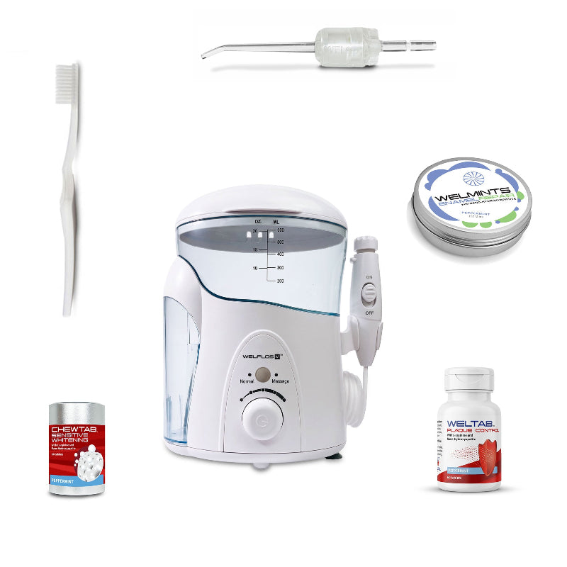 A white oral irrigator water flosser set with a clear water tank, handpiece, toothbrush, a clear Weltip, a small red-and-white bottle,  an aluminum container with mints, and a white-and-red bottle on a plain white background.